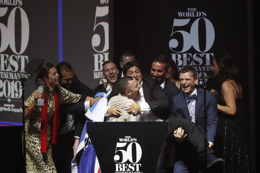 epa07673025 Chef Mauro Colagreco (C) and his wife Julia Colagreco (L) celebrate after their restaurant Mirazur, located in Menton, France, wins the award for Best Restaurant in the World, and the Best ...