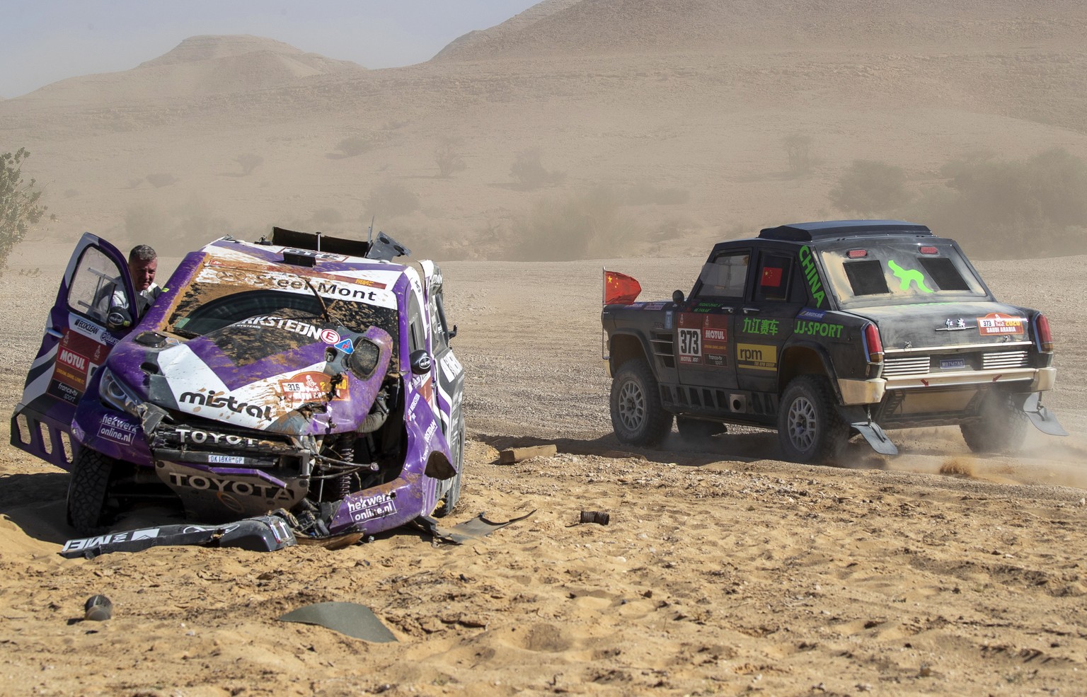 epa08127465 Chinese driver Aidong Li of the Qian&#039;an Jiu Jiang Landsail Racing Club team (R) passes the site of an accident of Dutch driver Peter van Merksteijn of the Overdrive Toyota team and hi ...