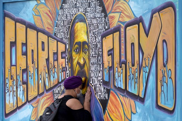 FILE - In this April 23, 2021, file photo, Damarra Atkins pays her respects to George Floyd at a mural at George Floyd Square, in Minneapolis. A fund set up to honor George Floyd says it has awarded m ...