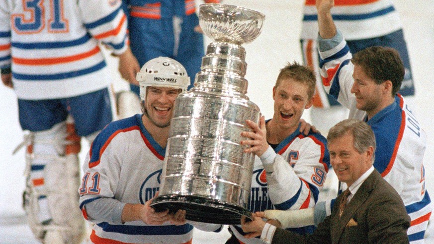 Edmonton Oilers team captain Wayne Gretzky, right, and Mark Messier hold up the Stanley Cup trophy following the team&#039;s 6-3 win over the Boston Bruins in the Stanley Cup hockey finals in Edmonton ...