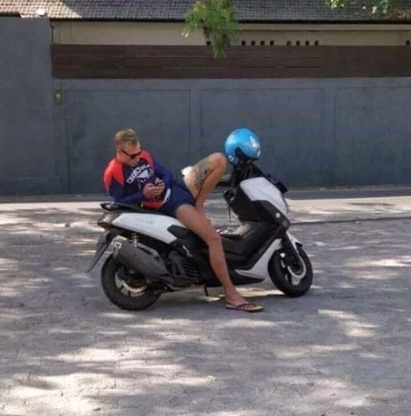 Perplexing perspective: a man and a woman on a motorbike