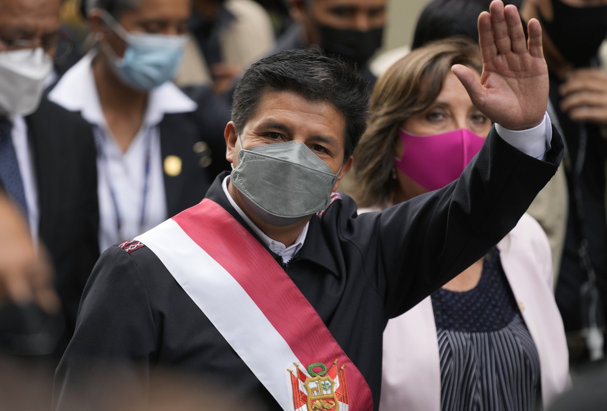 Peru's President Pedro Castillo waves to reporters while walking to Congress where lawmakers voted to proceed with impeachment proceedings against him, in Lima, Peru, Tuesday, March 15, 2022. (AP ...