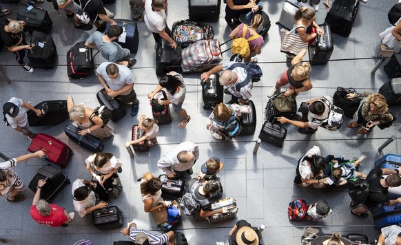 Fluggaeste schlaengeln sich um den Check-In Schalter auf dem Flughafen in Zuerich, aufgenommen am Sonntag, 15. Juli 2018. (KEYSTONE/Ennio Leanza)