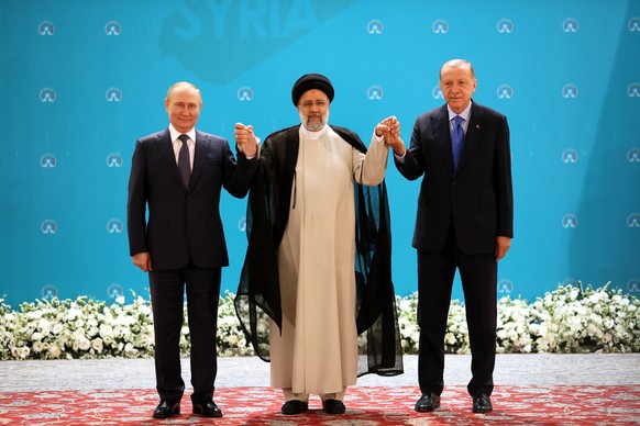 epa10080486 (L-R) Russian President Vladimir Putin, Iranian President Ebrahim Raisi and Turkish President Recep Tayyip Erdogan pose for a picture during a trilateral summit on Syria in Tehran, Iran, 1 ...