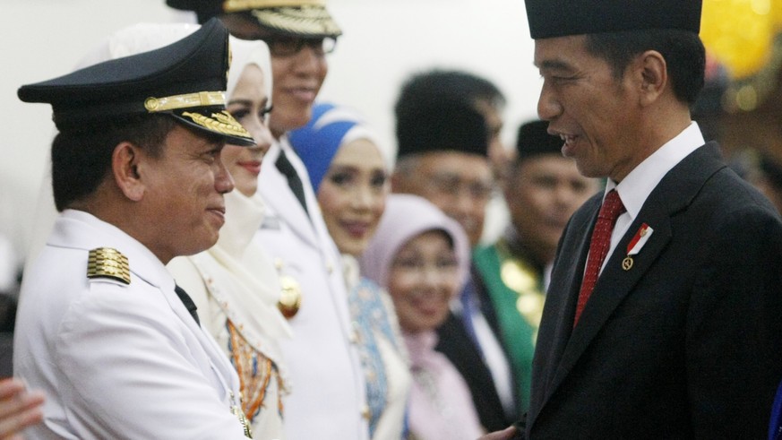 epa06066754 New Aceh Governor Irwandi Yusuf (C-R) shakes hands with Indonesian President Joko Widodo (C-L) during the governor&#039;s inauguration ceremony in Banda Aceh, 05 July 2017. Irwandi Yusuf,  ...