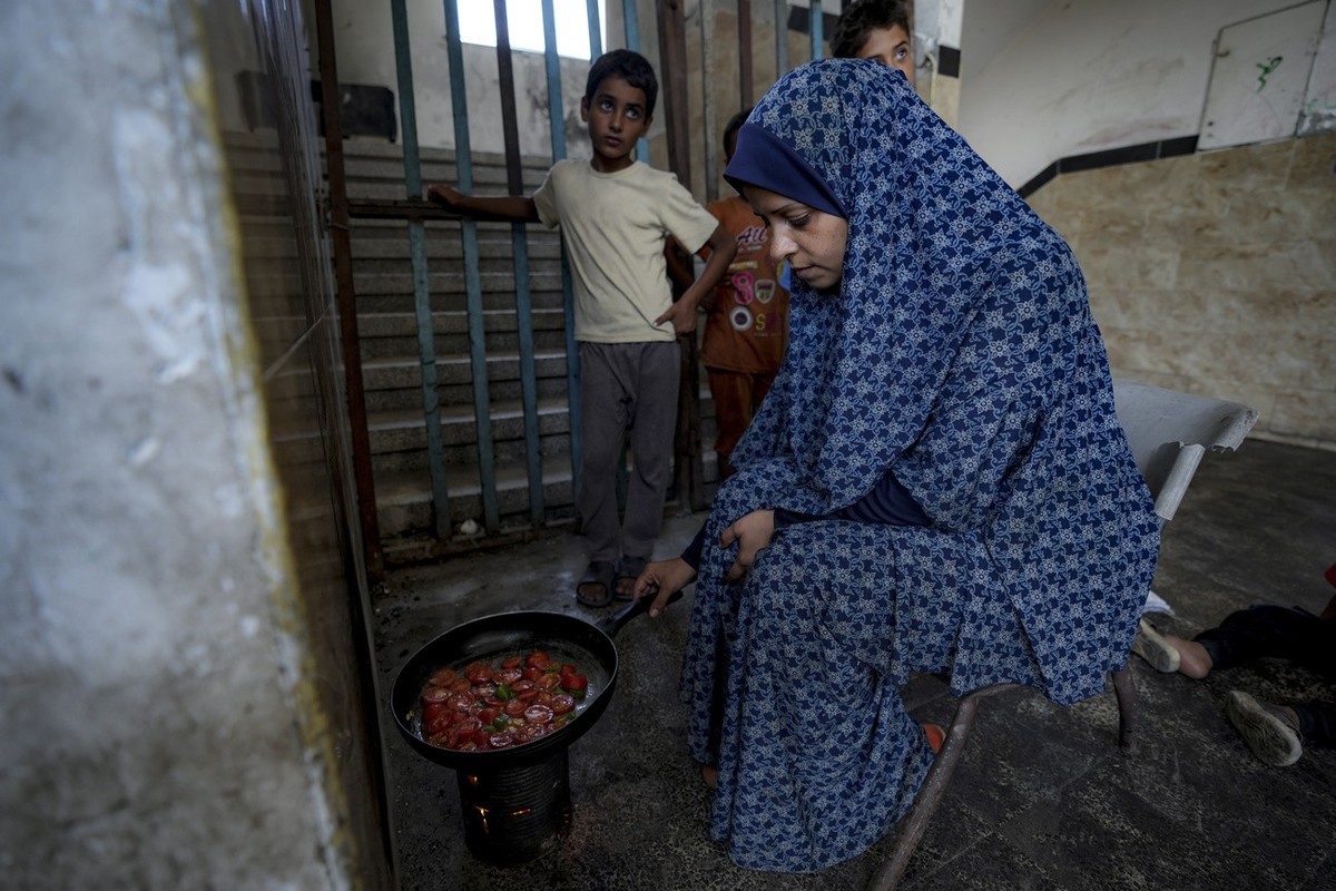 Nabila Hamada, who was displaced by the Israeli bombardment of the Gaza Strip, cooks in a UN-run school in Khan Younis, southern Gaza Strip, Wednesday, June 26, 2024. Hundreds of thousands of Palestin ...