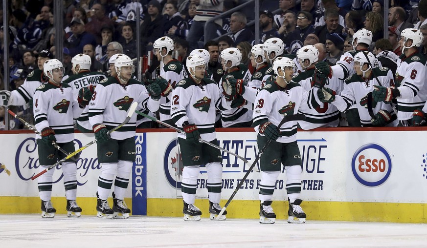 Minnesota Wild players celebrate a goal by Jason Pominville (29) against the Winnipeg Jets during the second period of an NHL hockey game Tuesday, Feb. 7, 2017, in Winnipeg, Manitoba. (Trevor Hagan/Th ...