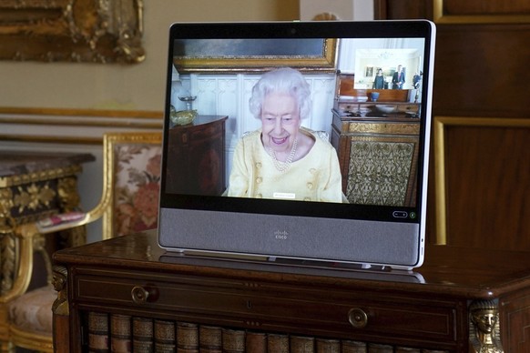 Queen Elizabeth II appears on a screen via videolink from Windsor Castle, where she is in residence, during a virtual audience at Buckingham Palace, London, Tuesday, Oct. 26, 2021. (Victoria Jones/Poo ...