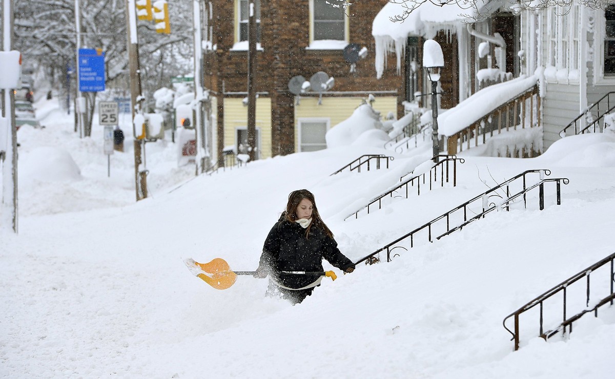 Rochelle Carlotti, 28, shovels steps near her home after a record snowfall on Tuesday, Dec. 26, 2017, in Erie, Pa. The National Weather Service office in Cleveland says Monday's storm brought 34  ...