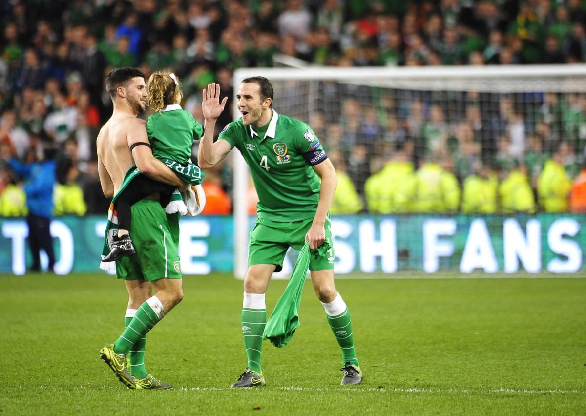 epa05028873 Ireland's Shane Long (L) celebrates with his daughter and his teammate John O'Shea (R) after the UEFA EURO 2016 qualification playoff second leg soccer match between Ireland and  ...
