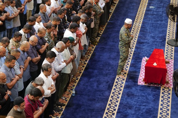 Maldivian President Mohamed Muizzu along with National Defense Force members prays in front of the remains of military diver Mohamed Mahudhee who died during search and rescue operation of four Italia ...