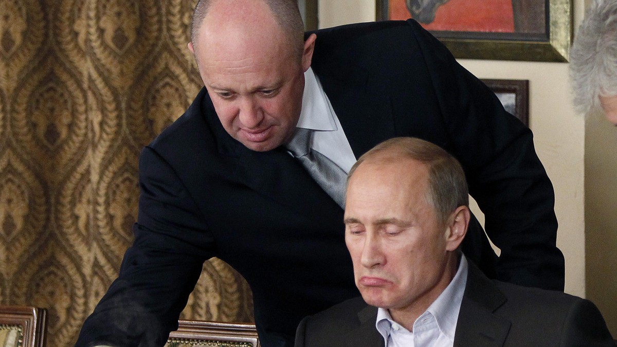 FILE - Yevgeny Prigozhin, top, serves food to then-Russian Prime Minister Vladimir Putin at Prigozhin's restaurant outside Moscow, Russia on Nov. 11, 2011. Prigozhin, the millionaire owner of the ...