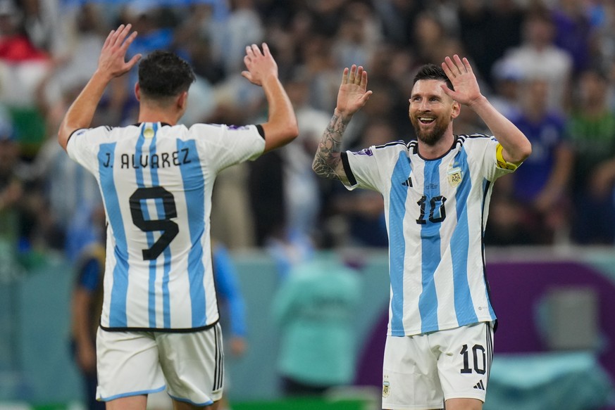 Argentina&#039;s Lionel Messi, right, congratulates teammate Julian Alvarez after scoring their third goal during the World Cup semifinal soccer match between Argentina and Croatia at the Lusail Stadi ...
