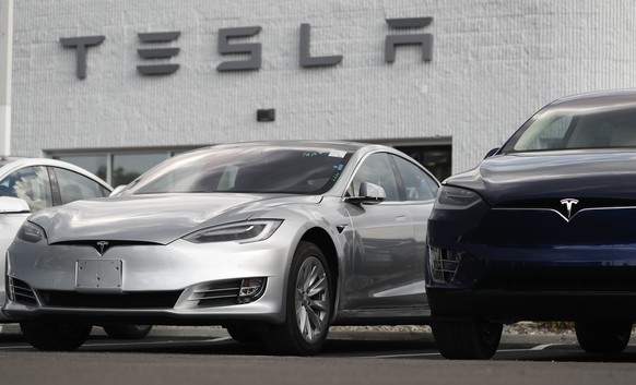 In this July 8, 2018, photo, 2018 Model 3 sedan sits next to a Model X on display outside a Tesla showroom in Littleton, Colo. Tesla CEO Elon Musk announced Tuesday, Aug. 7, that he is considering tak ...