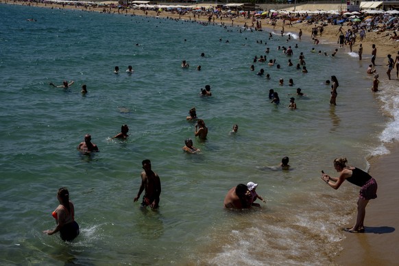 People cool off on a beach in Barcelona, Spain, Wednesday, Aug. 9, 2023. Spain is experiencing several days of extreme summer heat with the national AEMET weather agency saying temperatures will conti ...
