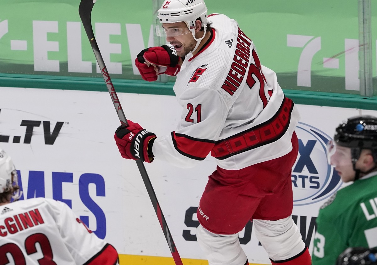 Carolina Hurricanes right wing Nino Niederreiter (21) celebrates his goal as teammate Brock McGinn (23) and Dallas Stars' Esa Lindell, right, look on in the third period of an NHL hockey game in  ...
