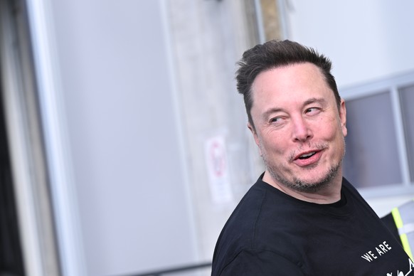 13.03.2024, Brandenburg, Gr�nheide: Tesla-Chef Elon Musk geht durch die Tesla Gigafactory Berlin-Brandenburg. Nach einem Anschlag auf die Stromversorgung des Elektroautobauers Tesla ist das Werk nach  ...