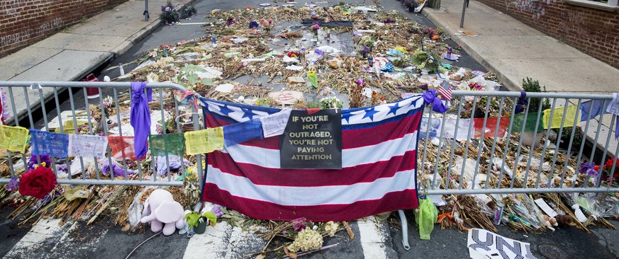 epa06159869 Flowers, candles and other items are placed in memory of Heather Heyer and for those affected by the violence at the site where a vehicle smashed into counter-protesters in Charlottesville ...