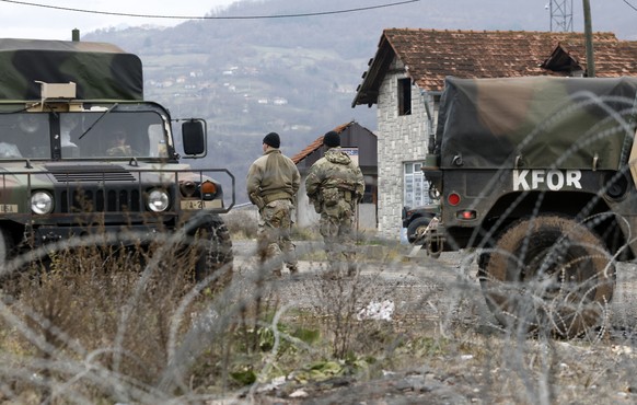 US soldiers serving in NATO-led peacekeeping force KFOR, guard a checkpoint on the road near the northern Kosovo border crossing of Jarinje, along the Kosovo-Serbia border, Kosovo, Sunday, Dec. 18, 20 ...