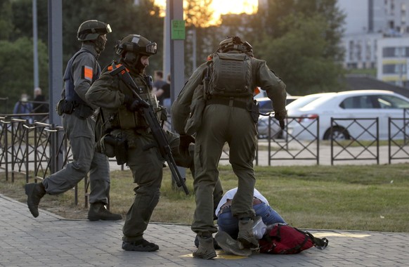 FILE - In this Aug. 10, 2020, file photo, police officers kick a demonstrator during a mass protest following presidential election in Minsk, Belarus. Political prisoners in Belarus are coming under i ...