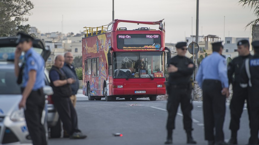 Police officers stand next to an open-top double-decker tourist bus that slammed into a low-hanging tree branch killing two people and injuring 45 others, including a dozen children, in the tourists d ...