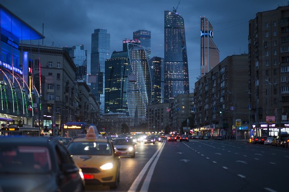 Traffic moves along the multi-lane highway in Moscow, with the modern city skyscrapers illuminating the skyline in Moscow, Russia, Friday, July 8, 2016. Moscow city is up-to-date and constantly changi ...