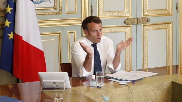 epa08366733 French President Emmanuel Macron (C) attends a video conference call with French virologist and President of the Research and Expertise Analysis Committee (Comite Analyse Recherche et Expe ...