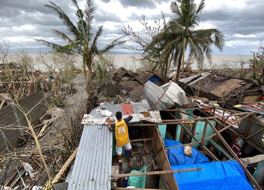 epaselect epa08790401 A Filipino villager repairs a damaged home in the typhoon-hit town of Sagnay, Camarines Sur, Philippines, 01 November 2020. Super Typhoon Goni, with winds forecasted to reach ove ...