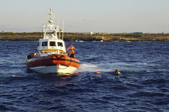 FILE - A man who threw himself in the water from the Open Arms vessel, is intercepted by the Italian Coast guards as he tried to swim to the island of Lampedusa, southern Italy, Tuesday, Aug. 20, 2019 ...