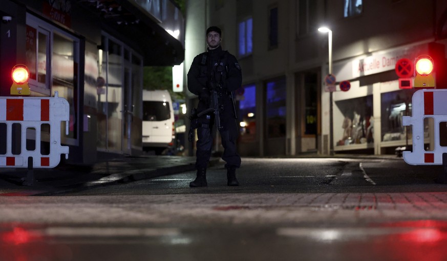 epa11562300 A police officer stands guard after a knife attack during the city festival in a street in Solingen, Germany, 23 August 2024. According to the police, at around 9.45 pm a man stabbed passe ...