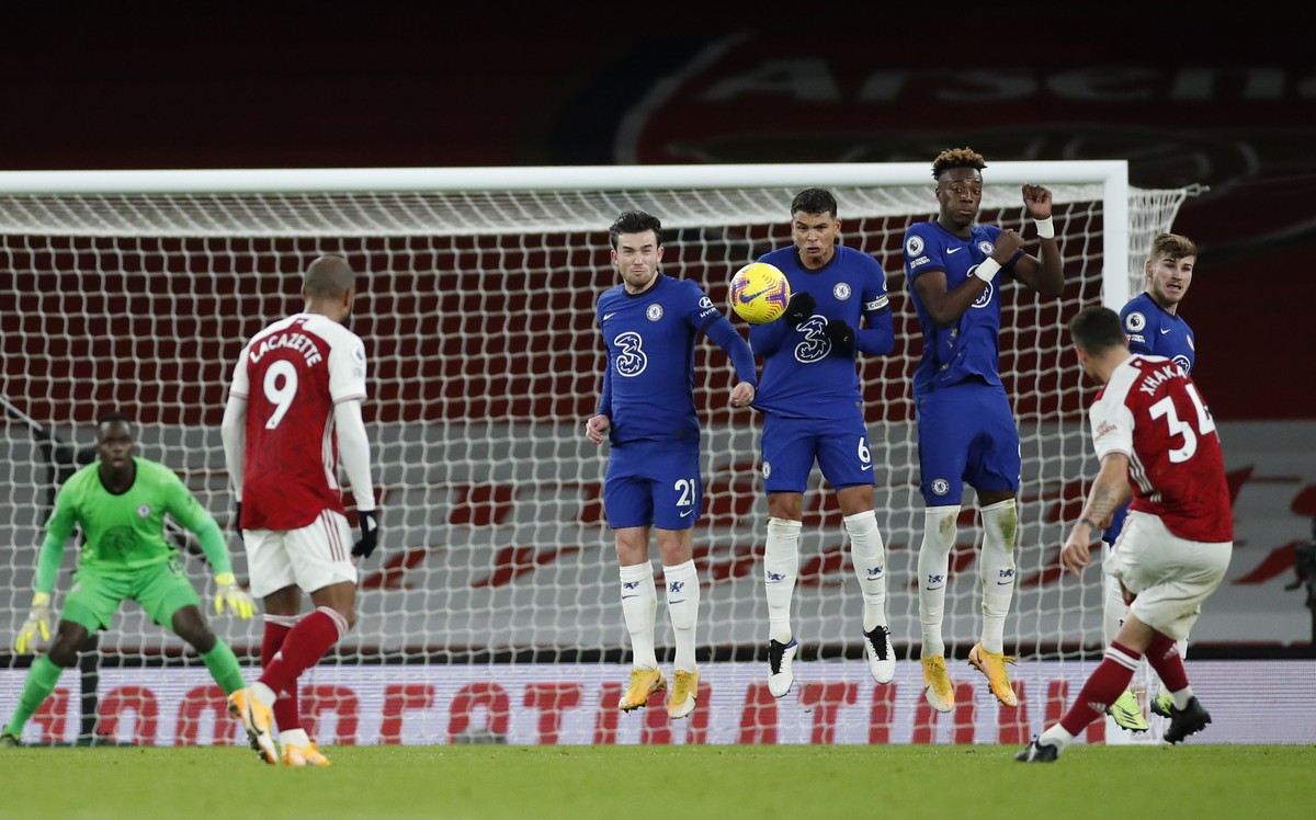 Arsenal's Granit Xhaka, right (34), watches as his free kick goes over the wall scoring his sides 2nd goal of the game during their English Premier League soccer match between Arsenal and Chelsea ...