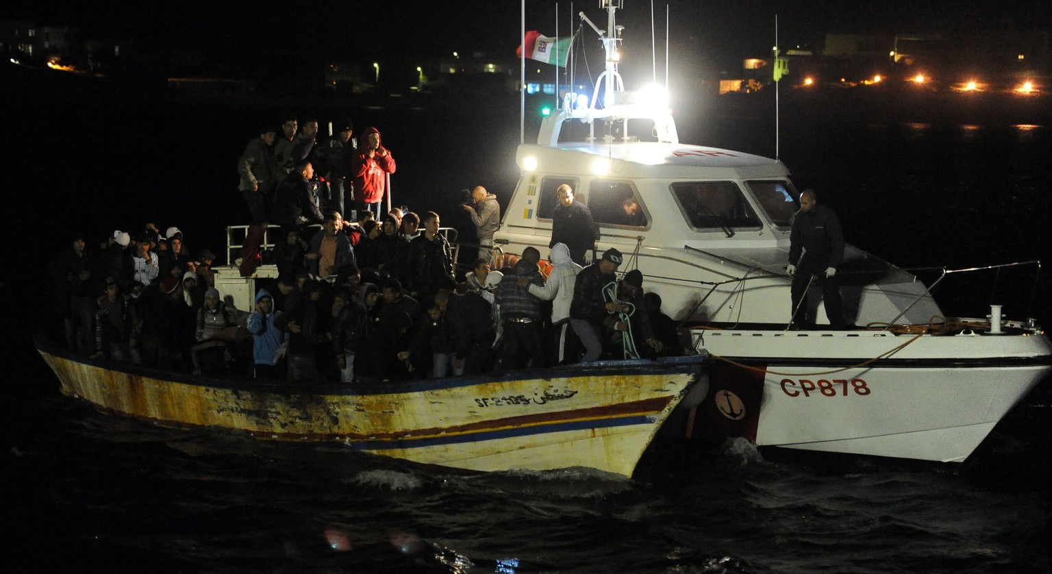 Ein schrottreifer Kahn mit Flüchtlingen wird von der italienischen Küstenwache aufgebracht.