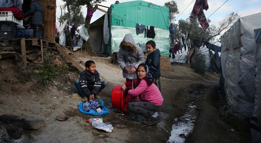 epa08112466 Children help with the laundry in the refugee camp of Moria, on Lesvos island, Greece, 08 January 2020. In the camp, meant to host 2500 migrants and refugees, nowdays are living more than  ...