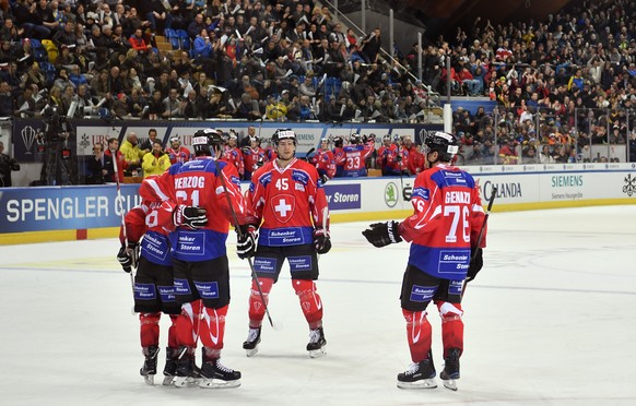Team Suisse player Lino Martschini, left, celebrates scoring 6-1 with teammates during the game between Team Suisse and Dinamo Riga at the 91th Spengler Cup ice hockey tournament in Davos, Switzerland ...