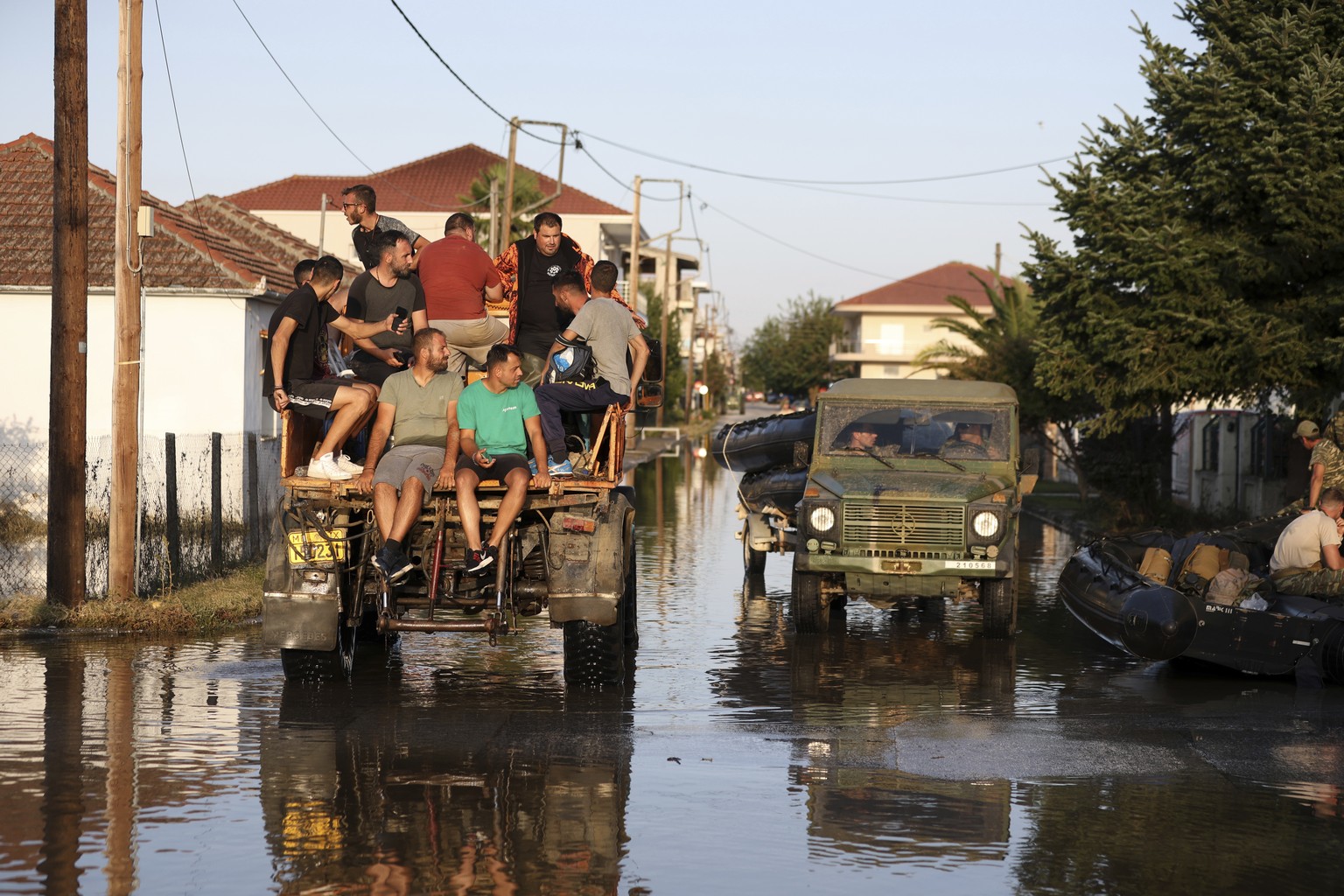 Local residents and members of the Greek army cross the flooded town of Palamas, near Karditsa, Thessaly region, central Greece, Friday, Sept. 8, 2023. Rescue crews in helicopters and boats are plucki ...