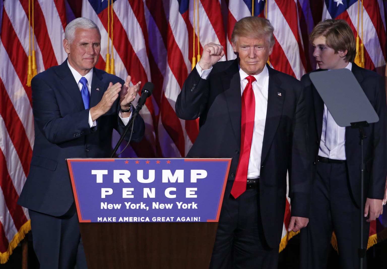 epa05623720 US Republican presidential nominee Donald Trump (C) waves next to running mate Mike Pence (L) as he delivers a speech on stage at Donald Trump&#039;s 2016 US presidential Election Night ev ...