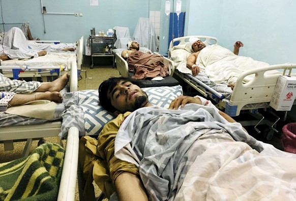 Wounded Afghans lie on a bed at a hospital after a deadly explosions outside the airport in Kabul, Afghanistan, Thursday, Aug. 26, 2021. Two suicide bombers and gunmen attacked crowds of Afghans flock ...