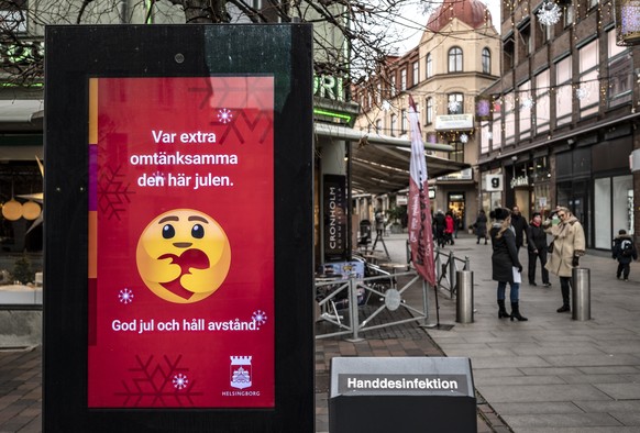 epa08868398 An information sign wishing Merry Christmas and asking to maintain social distancing is seen in a pedestrian shopping street in Helsingborg, southern Sweden, 07 Decmber 2020. The last week ...