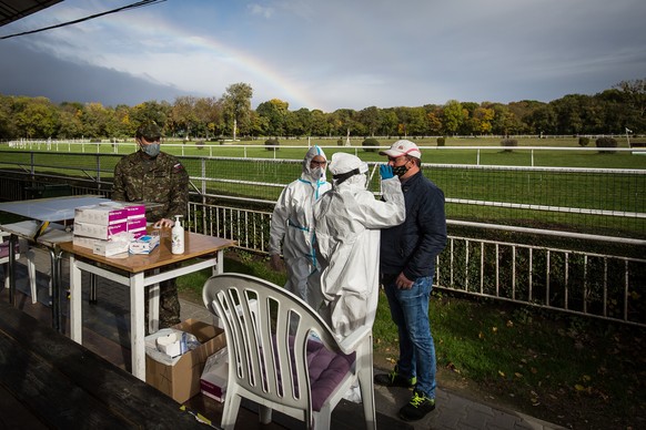 epaselect epa08788084 A healthcare worker collects a swab sample from a person at a coronavirus disease testing site during nationwide testing in Bratislava, Slovakia, 31 October 2020. EPA/JAKUB GAVLA ...