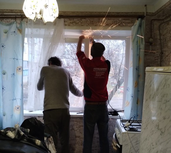 Im Pulli der Knecht Gmbh aus Kemptthal (laut Hebeisens Informationen gekauft in einem Second-Hand-Laden) montiert ein Ukrainer das eingedrückte Fenster zurück in die Zarge.