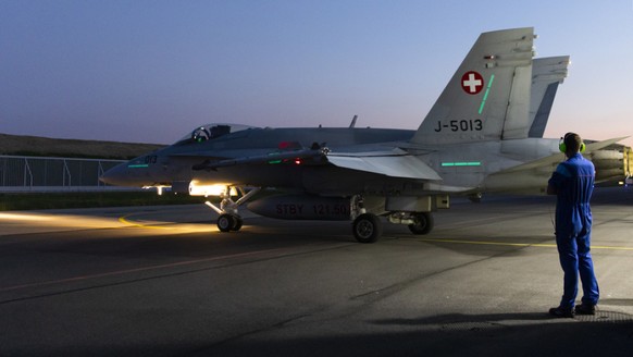 Ein F/A-18 Flugzeug rollt aus dem Hangar.