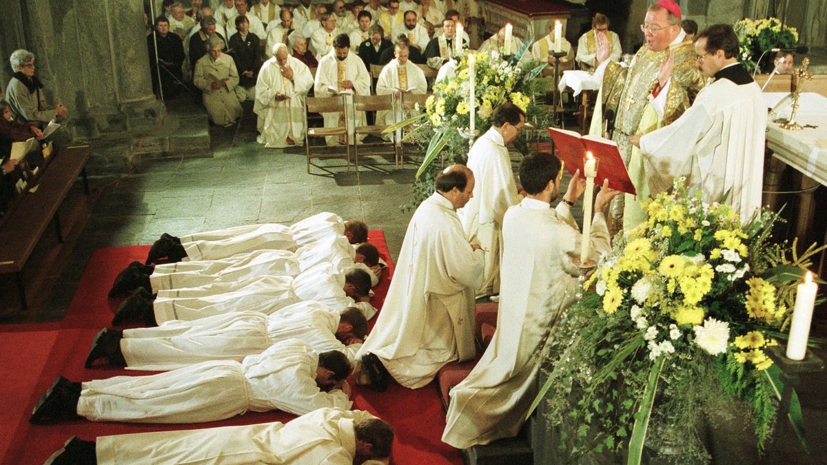 Der Churer Bischof Wolfgang Haas (oben rechts) weiht am Samstag, 22. November 1997, in der Kathedrale in Chur neun Diakone. (KEYSTONE/ARNO BALZARINI)