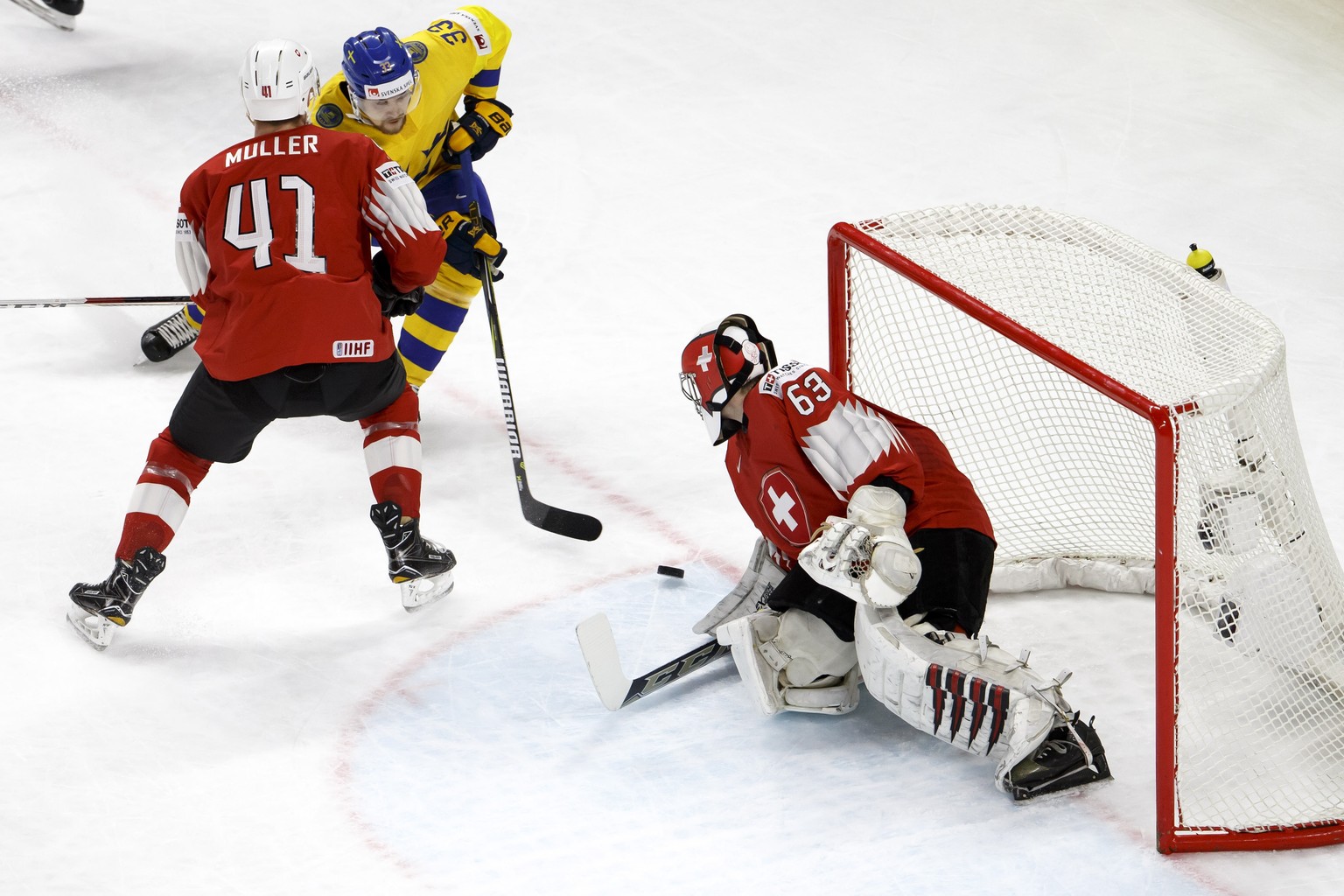 epa06752982 Switzerland&#039;s defender Mirco Mueller, left, vies for the puck with Sweden&#039;s forward Viktor Arvidsson, centre, past Switzerland&#039;s goaltender Leonardo Genoni, right, during th ...