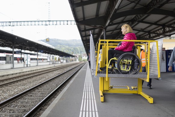 ZUM THEMA MENSCHEN MIT BEHINDERUNG IM OEFFENTLICHEN VERKEHR STELLEN WIR IHNEN HEUTE DIESES NEUE BILDMATERIAL ZUR VERFUEGUNG --- An SBB (Swiss Federal Railways) employee uses a lifting platform to help ...