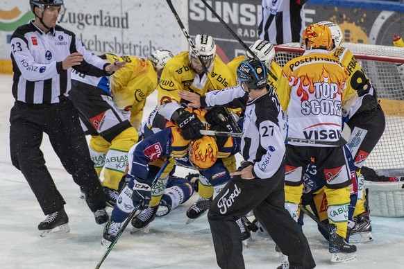 Gregory Hofmann, mitte, von Zug im Spiel gegen Simon Moser, oben, und Mark Arcobello, rechts, von Bern beim Eishockey Meisterschaftsspiel in der Qualifikation der National League zwischen dem EV Zug u ...