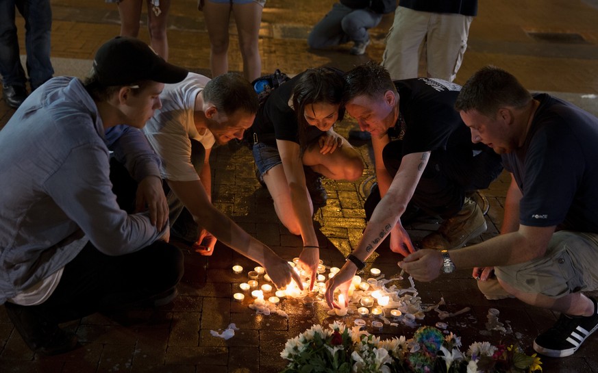 epa06141576 People place candles as they gather during a vigil in Charlottesville, Virginia, USA, 12 August 2017. According to media reports at least one person was killed and 19 injured after a car h ...