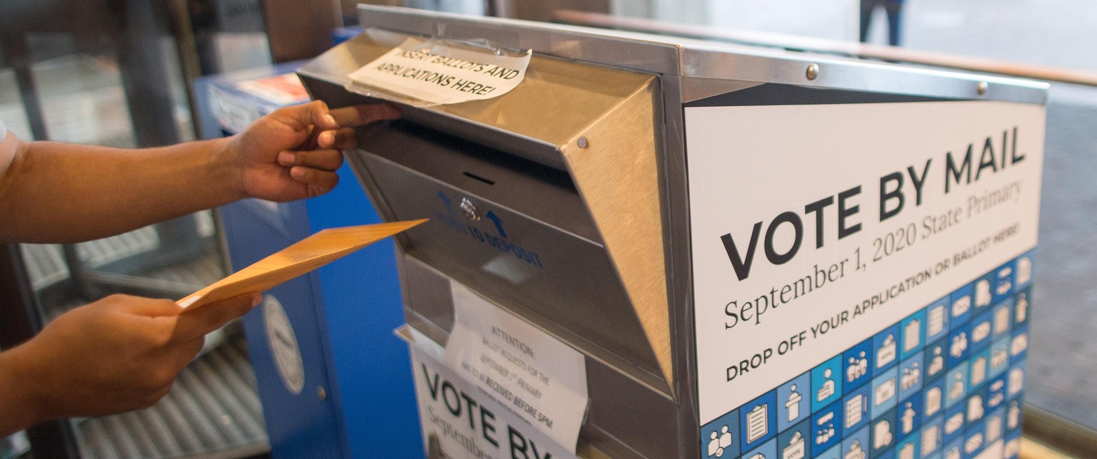 A voter casts their ballot at a vote by mail dropbox at Boston City Hall in Boston, Massachusetts, U.S., on Tuesday, Sept. 1, 2020. House Speaker Nancy Pelosi and outspoken progressive Democrat Alexan ...