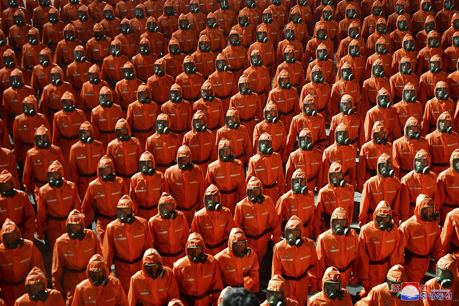 In this photo provided by the North Korean government, North Korean troops wearing gas masks and bright red suits parade during a celebration of the nation���s 73rd anniversary that was overseen by le ...