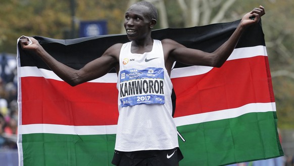 Geoffrey Kamworor of Kenya poses for pictures after crossing the finish line first in the men&#039;s division of the New York City Marathon in New York, Sunday, Nov. 5, 2017. (AP Photo/Seth Wenig)