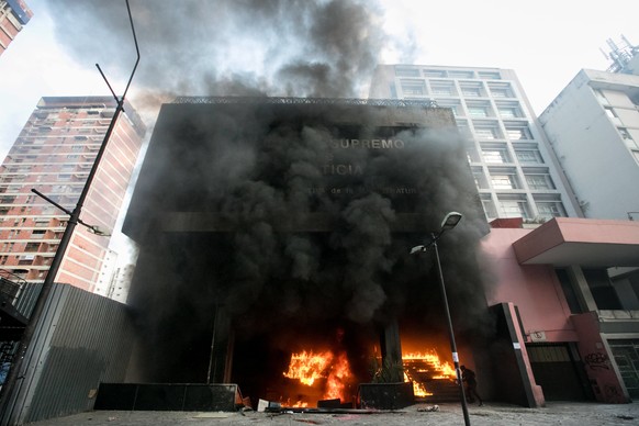 epa06025170 A general view of the burning building of the Executive Directorate of the Judiciary (DEM) of the Supreme Court of Venezuela in Caracas, Venezuela, 12 June 2017. An group of hooded people  ...